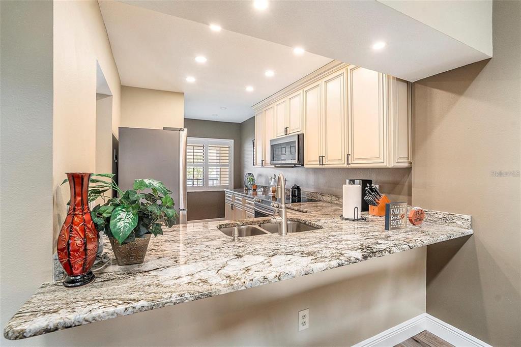 8210 Aquila Street, Unit 223 Port Richey, FL 34668 - Photo 9 of 36 a kitchen with stainless steel appliances granite countertop sink stove top oven and cabinets