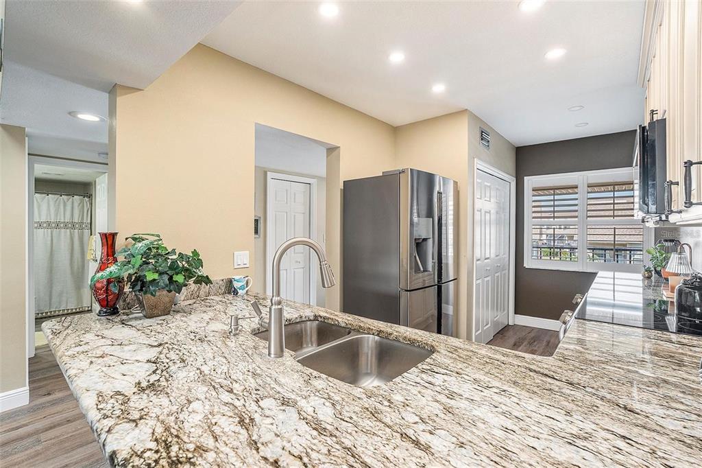 8210 Aquila Street, Unit 223 Port Richey, FL 34668 - Photo 10 of 36 a kitchen with stainless steel appliances kitchen island granite countertop a refrigerator and a sink