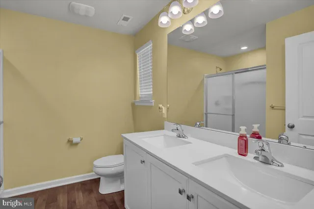 a bathroom with a sink vanity mirror and toilet