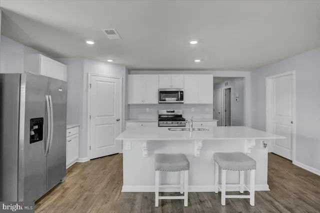 a kitchen with stainless steel appliances a refrigerator and a stove top oven