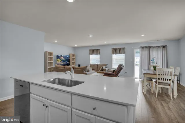 a view of a dining room with furniture a potted plant and wooden floor