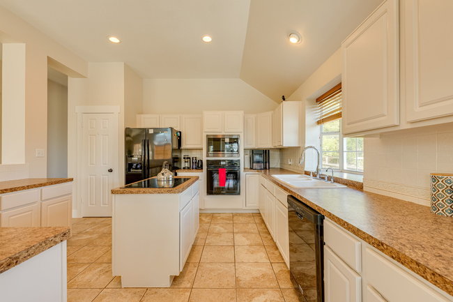 17909 Westward Look Dripping Springs, TX 78620 - Photo 14 of 40 a kitchen with stainless steel appliances granite countertop a sink and cabinets