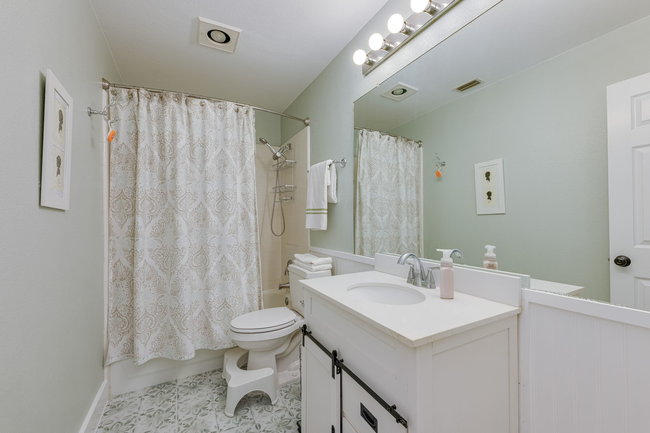 17909 Westward Look Dripping Springs, TX 78620 - Photo 24 of 40 a bathroom with a sink a toilet and shower