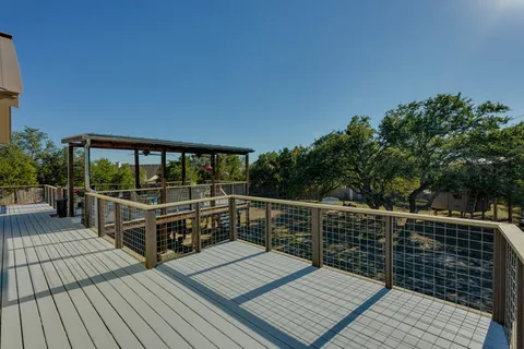 a view of balcony with wooden floor and fence