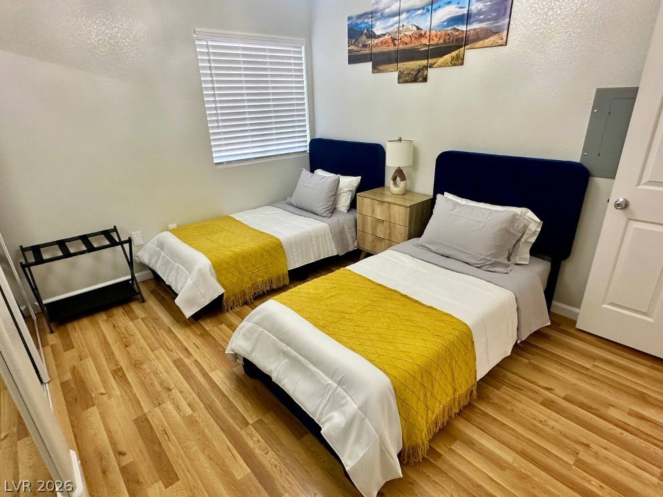 9580 West Reno Avenue, Unit 169 Las Vegas, NV 89148 - Photo 11 of 15 Two comfortable twin beds and light wood-tone flooring create a serene and functional bedroom space.