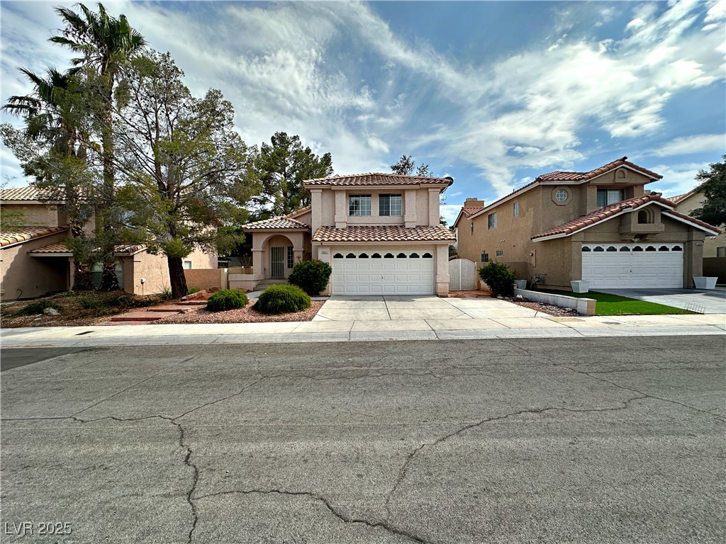 Mediterranean / spanish house featuring driveway, stucco siding, a garage, and a tiled roof