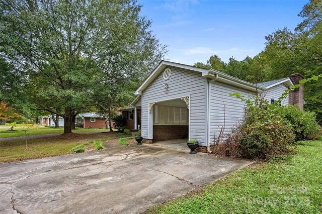 a view of a house with a yard and large tree