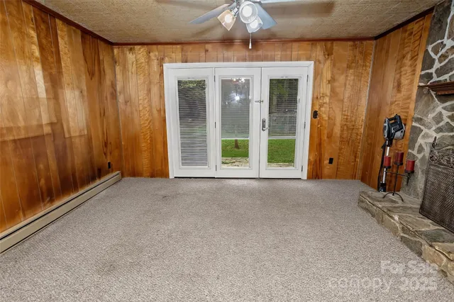 a view of an empty room with a fireplace and a window
