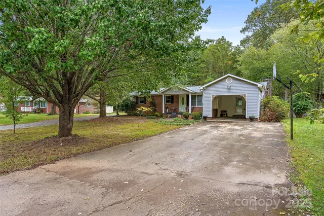 a front view of a house with a yard and trees