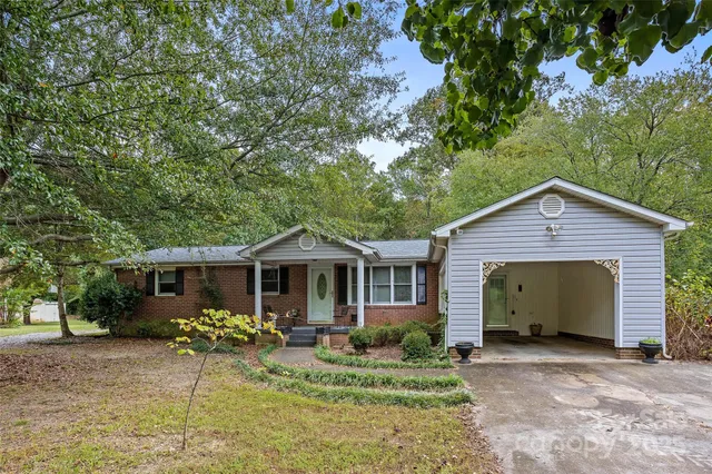 a view of a house with table and chairs under an umbrella