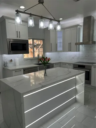 a kitchen with kitchen island a sink stainless steel appliances and cabinets