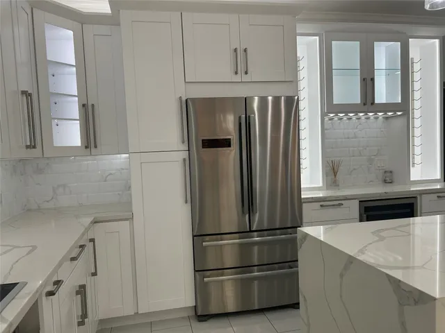 a kitchen with stainless steel appliances white cabinets and a refrigerator
