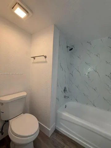 a white toilet and tub sitting next to a bathroom sink