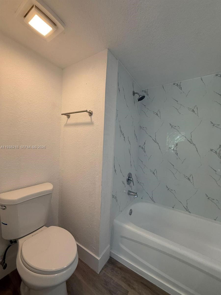 424 Northwest 84th Street, Unit 424 Miami, FL 33150 - Photo 12 of 15 a white toilet and tub sitting next to a bathroom sink