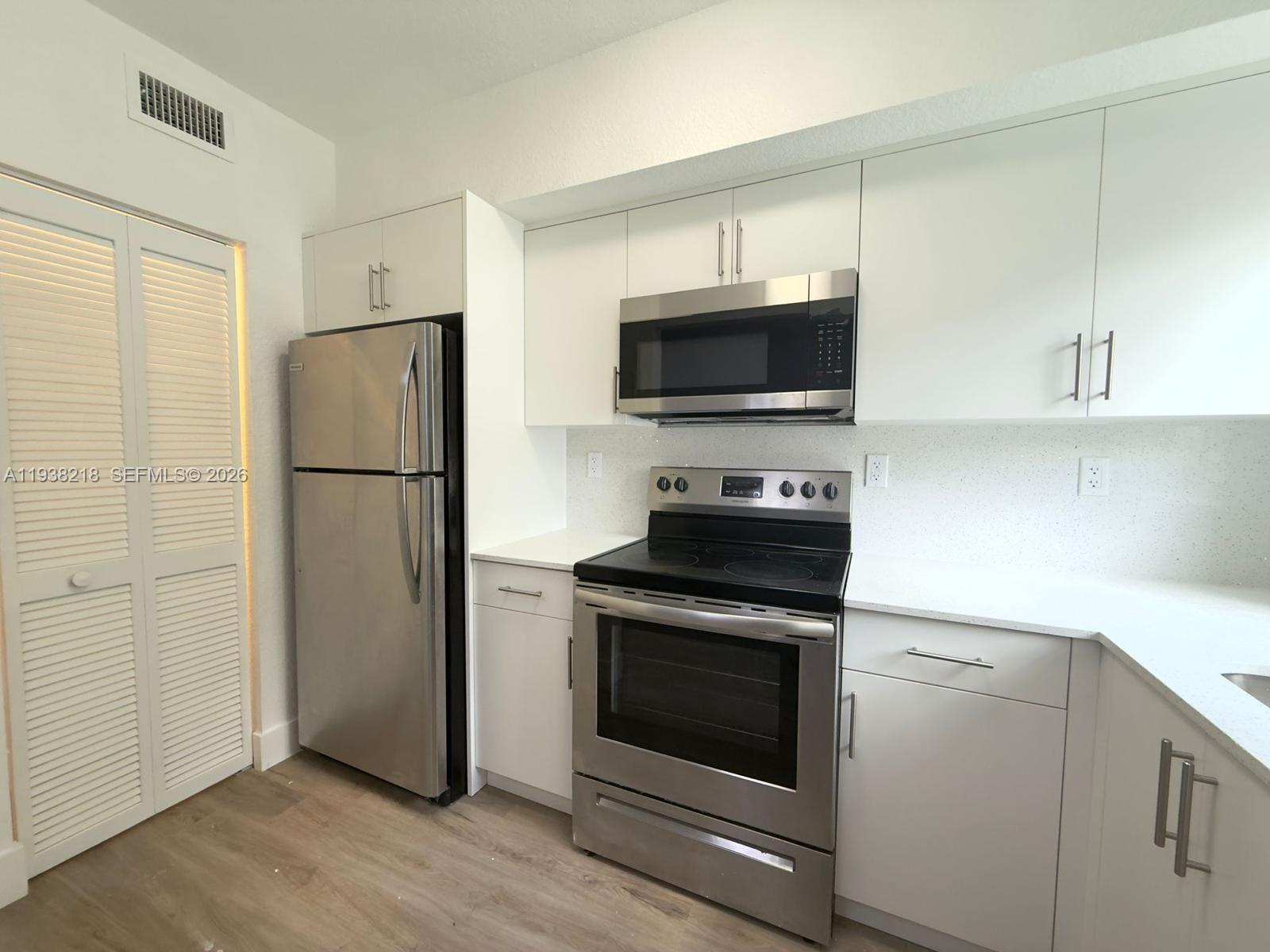 424 Northwest 84th Street, Unit 424 Miami, FL 33150 - Photo 3 of 15 a kitchen with a refrigerator stove and microwave