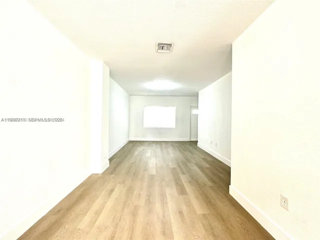 a view of hallway with wooden floor