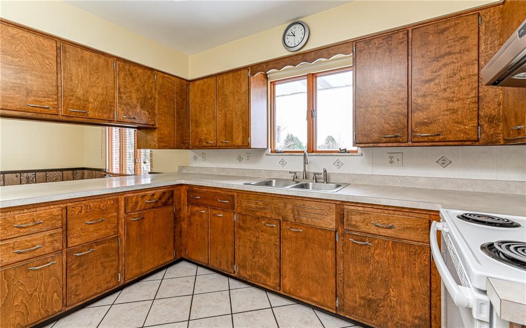 830 Hartzell School Road New Brighton, PA 15066 - Photo 10 of 31 a kitchen with wooden cabinets and a sink