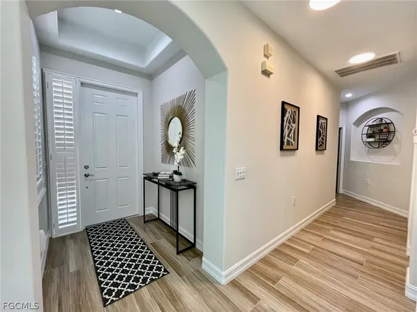 a view of a hallway with wooden floor and a bathroom