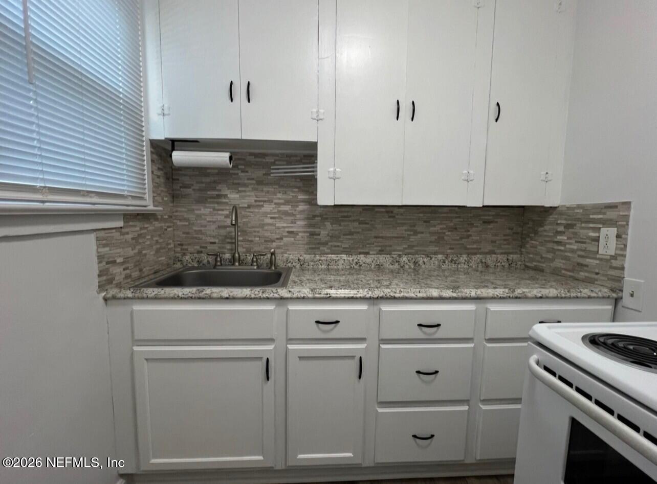 7307 Clinton Street Jacksonville, FL 32208 - Photo 11 of 17 a kitchen with white cabinets and white appliances