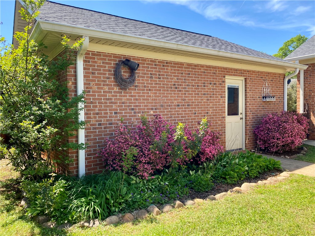 2026 Cardinal Park Drive Anderson, SC 29621 - Photo 8 of 41 Brick exterior featuring lush landscaping, a durable roof, and convenient rain gutters.