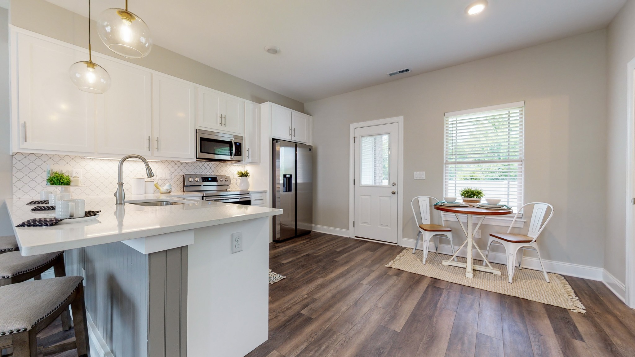 555 Gresham Lane, Unit 7C Murfreesboro, TN 37128 - Photo 6 of 19 a kitchen with microwave a stove a sink a dining table and chairs