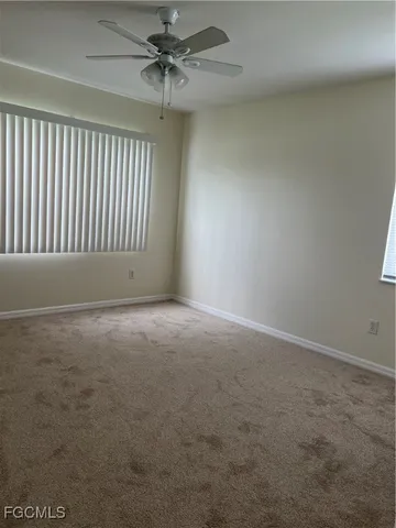 en empty room with windows and fan