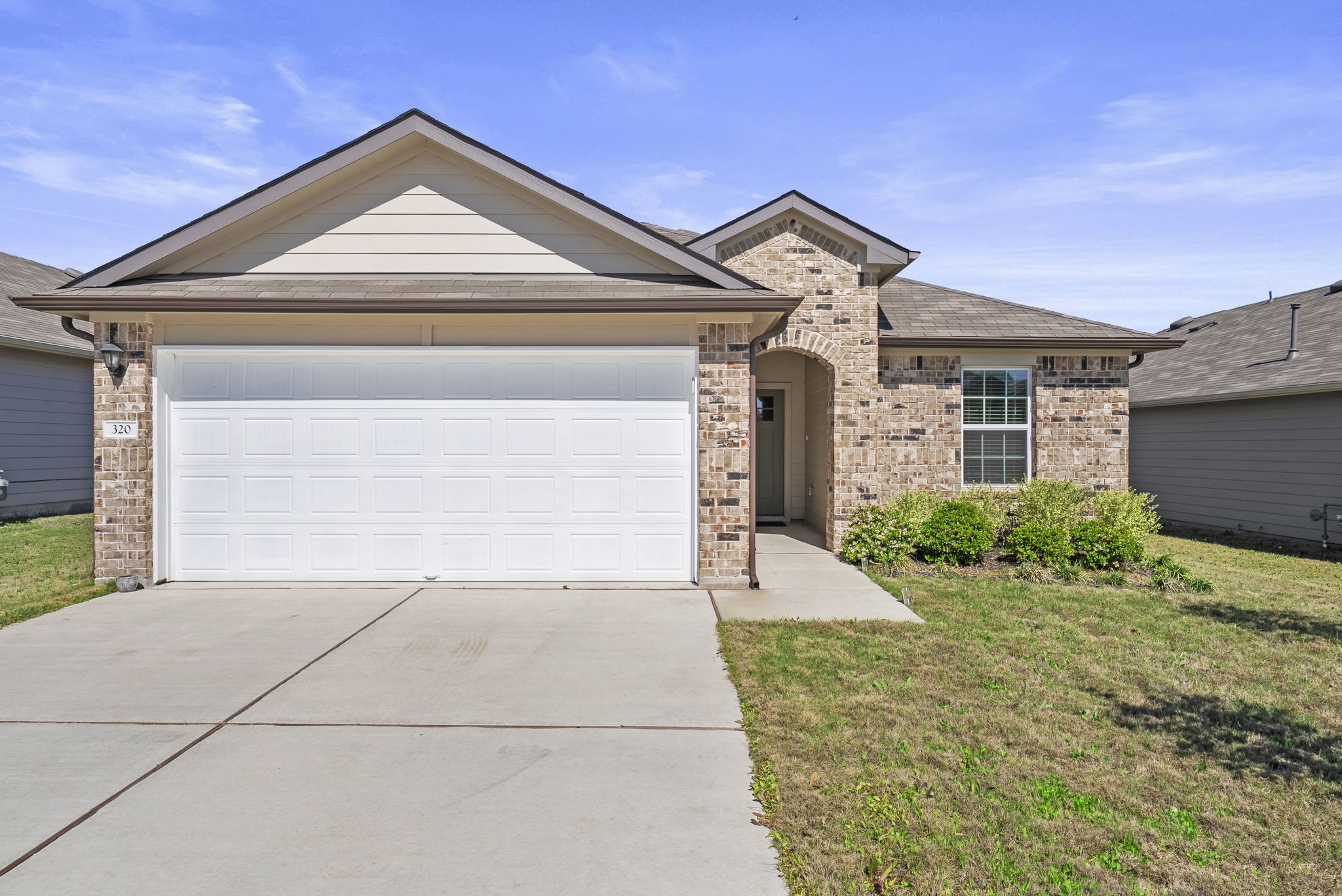 320 Darwin Place Lockhart, TX 78644 - Photo 1 of 31 View of front of house featuring a garage, brick siding, concrete driveway, and a front yard