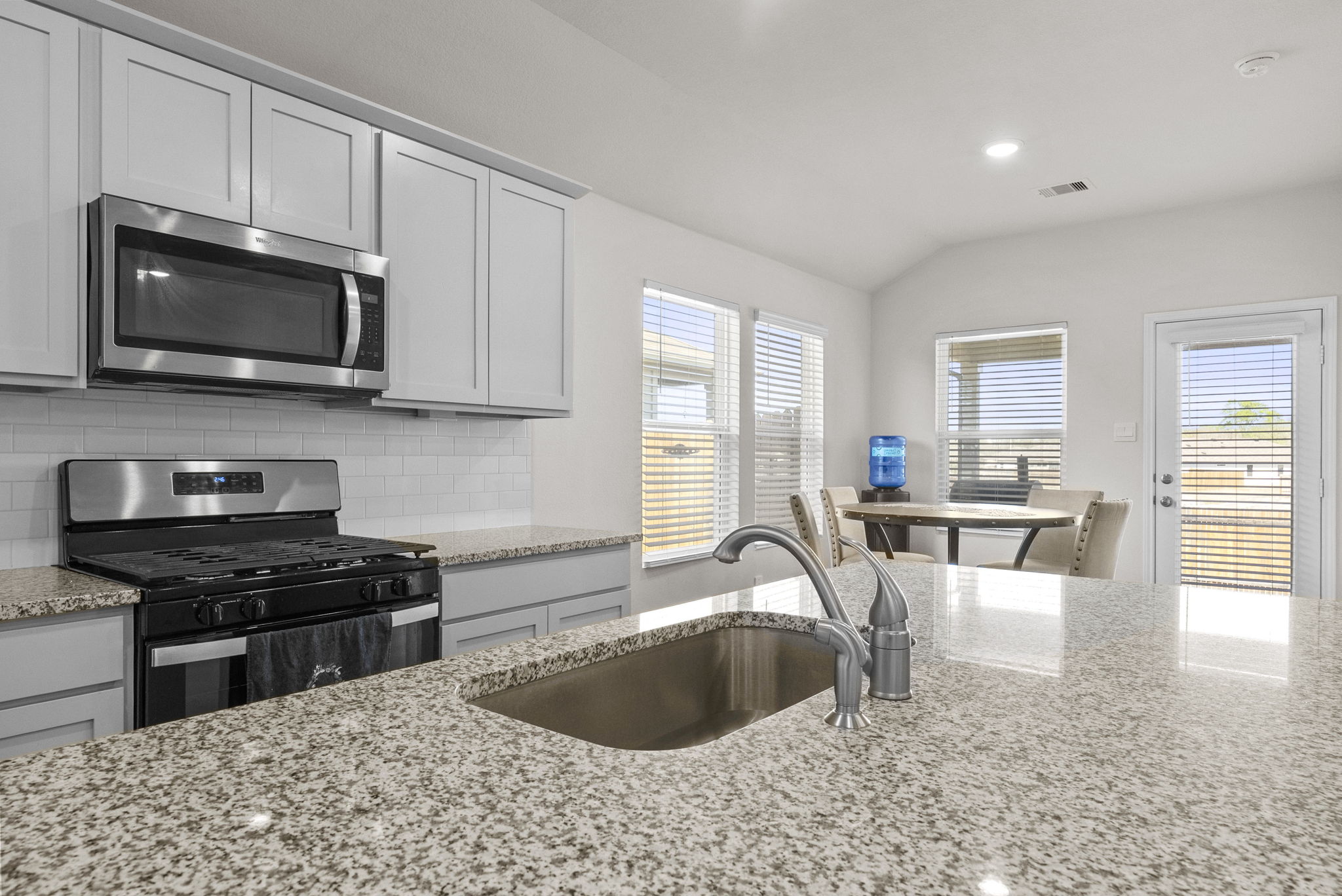 320 Darwin Place Lockhart, TX 78644 - Photo 19 of 31 Kitchen featuring stainless steel appliances, decorative backsplash, light stone countertops, and recessed lighting