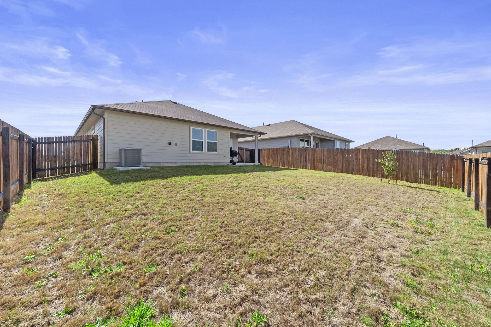 320 Darwin Place Lockhart, TX 78644 - Photo 6 of 31 Rear view of property featuring a fenced backyard and a patio area