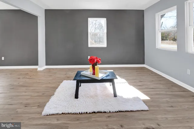 a living room with wooden floor and window