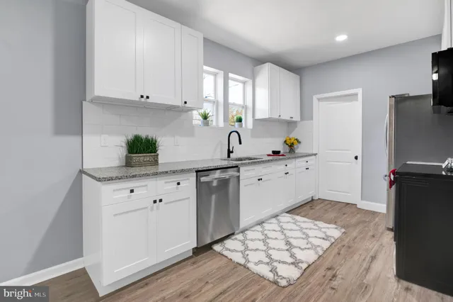 a kitchen with granite countertop a sink stainless steel appliances and cabinets