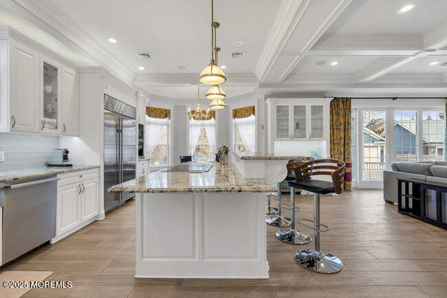 Undisclosed Address Spring Lake, NJ 07762 - Photo 17 of 67 a kitchen with granite countertop a stove a sink a dining table and chairs