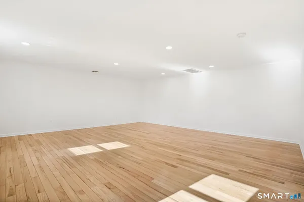 a view of empty room with wooden floor