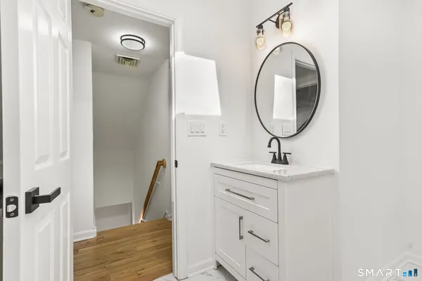 a white toilet sitting next to a white wall