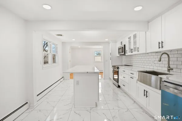 a large white kitchen with cabinets