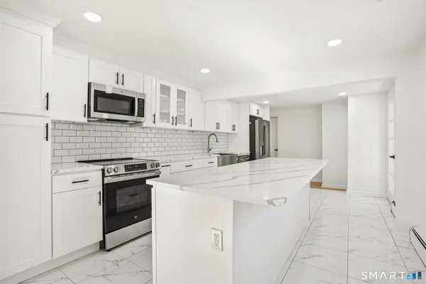 a kitchen with stainless steel appliances a stove sink microwave and cabinets