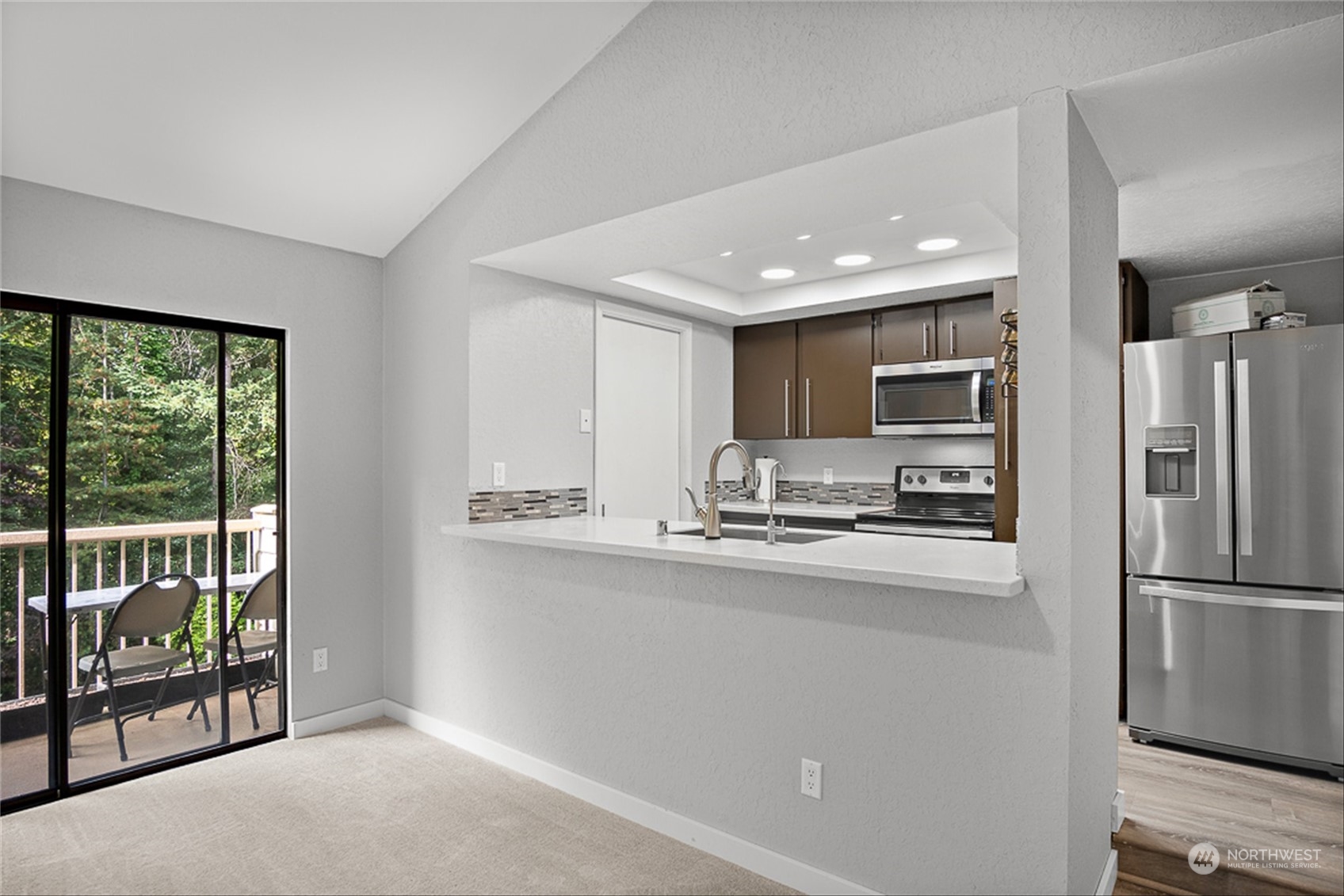 14401 Southeast Petrovitsky Road, Unit E202 Renton, WA 98058 - Photo 12 of 26 a kitchen with stainless steel appliances a refrigerator and a stove top oven