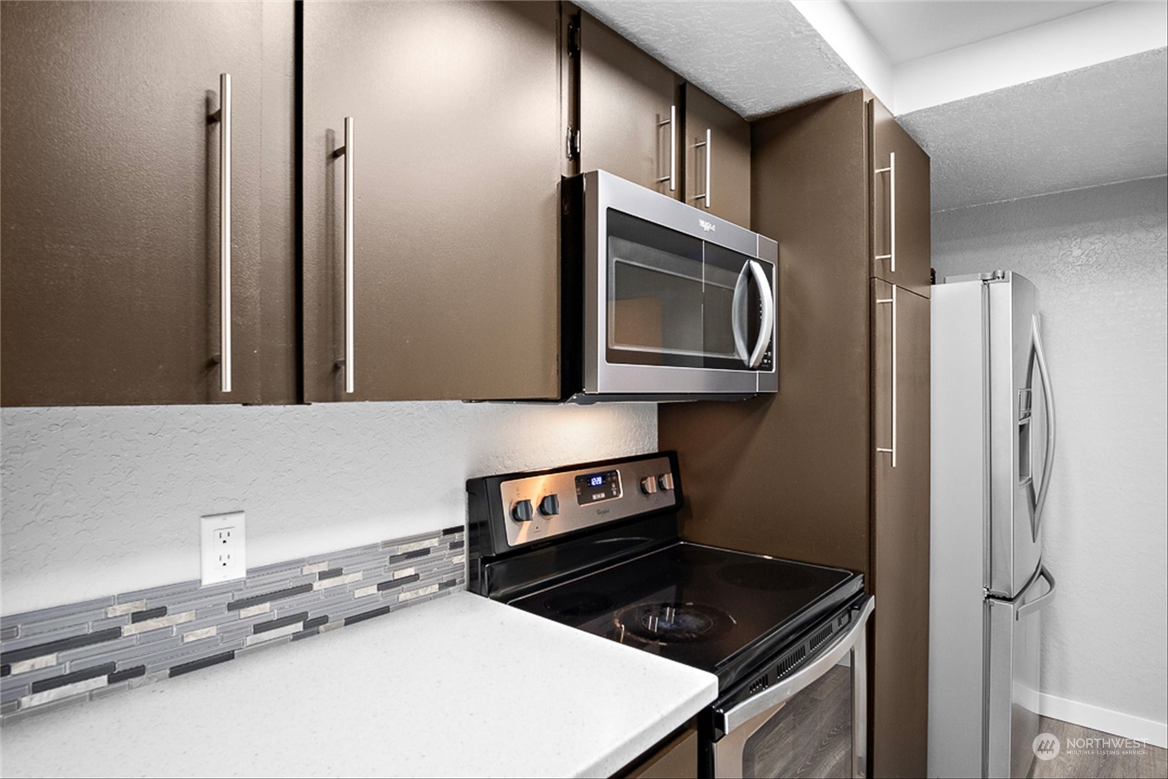 14401 Southeast Petrovitsky Road, Unit E202 Renton, WA 98058 - Photo 16 of 26 a kitchen with stainless steel appliances a stove a microwave and a refrigerator