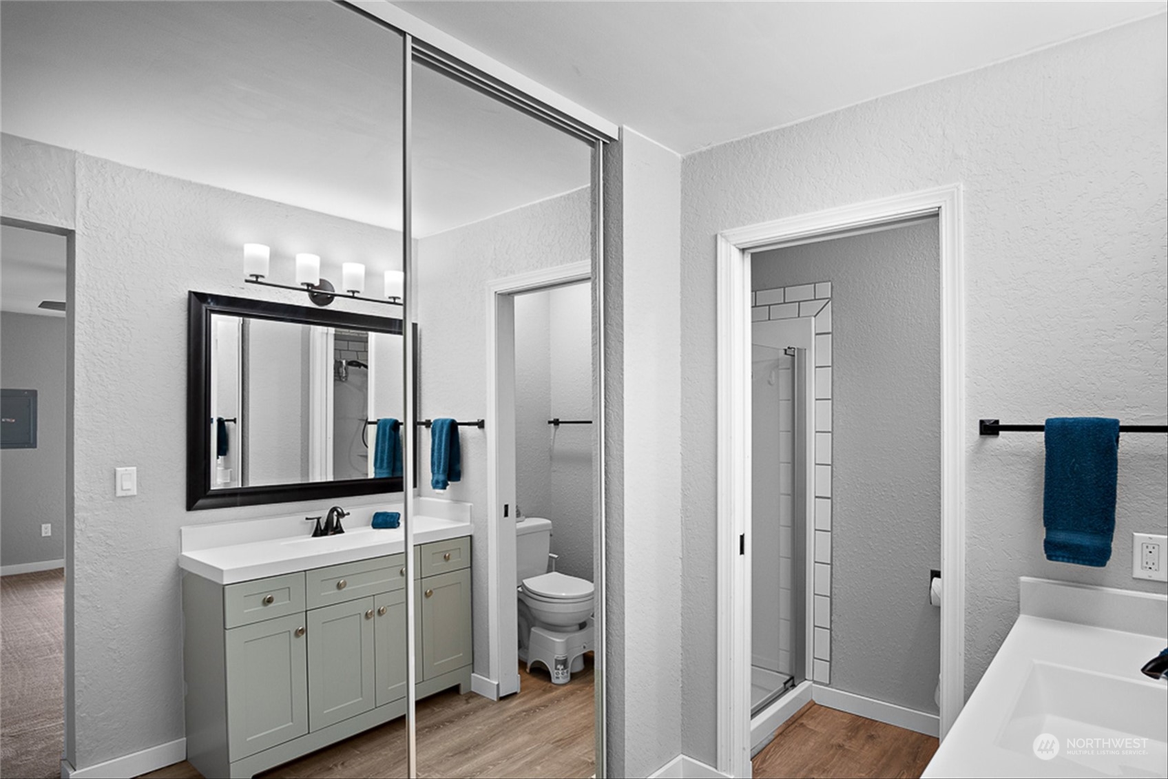 14401 Southeast Petrovitsky Road, Unit E202 Renton, WA 98058 - Photo 20 of 26 a bathroom with a double vanity sink and mirror with toilet