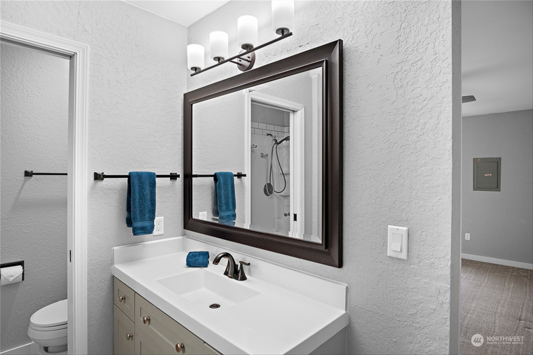 14401 Southeast Petrovitsky Road, Unit E202 Renton, WA 98058 - Photo 21 of 26 a bathroom with a toilet sink and mirror