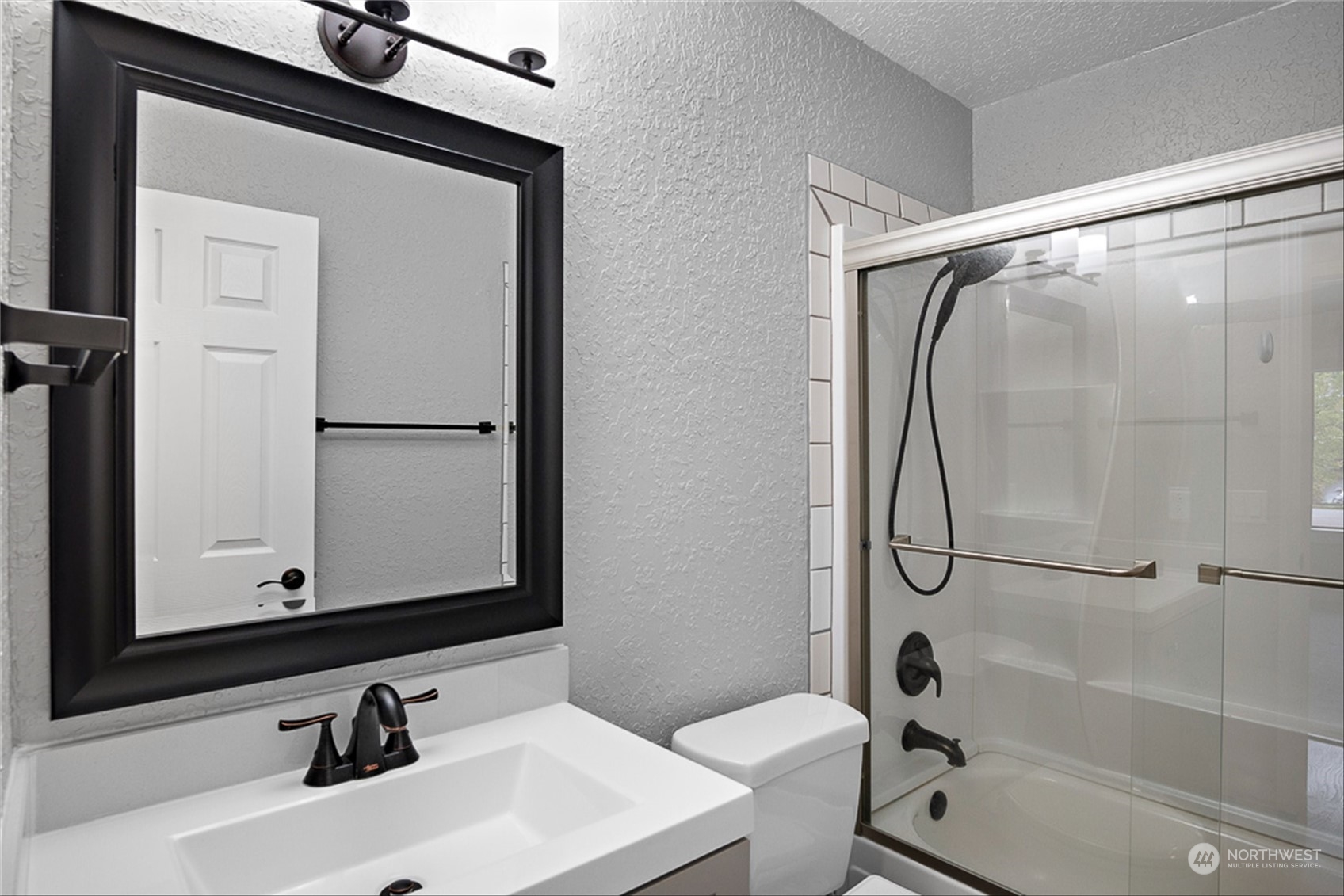 14401 Southeast Petrovitsky Road, Unit E202 Renton, WA 98058 - Photo 23 of 26 a bathroom with a sink a toilet and a mirror