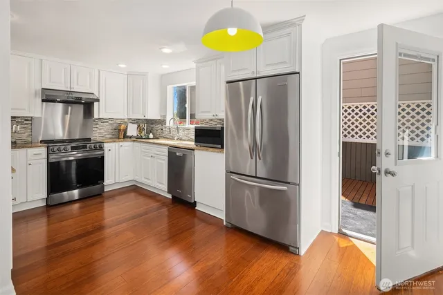 a kitchen with stainless steel appliances granite countertop a refrigerator sink and stove top oven