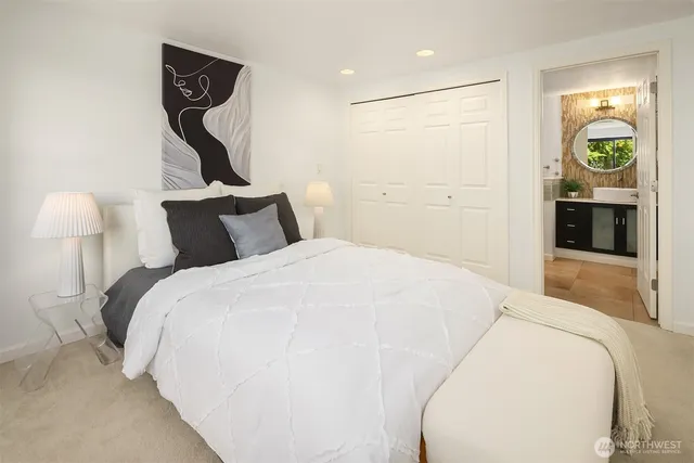 a spacious bedroom with a bed and a lamp on table