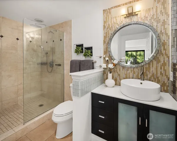 a bathroom with a sink a toilet and shower