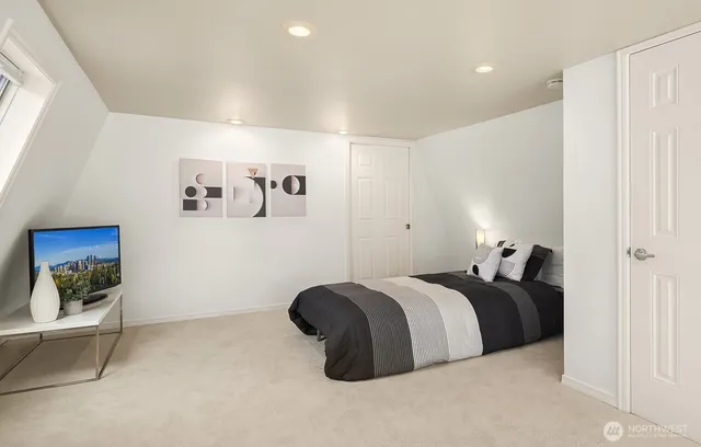 a bedroom with a bed and a painting on the wall