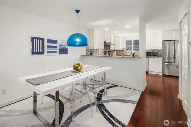 a kitchen with stainless steel appliances a dining table chairs and stove top oven
