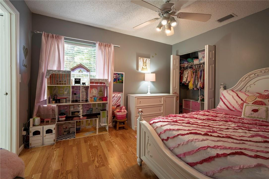 6960 Brook Hollow Road Lake Worth, FL 33467 - Photo 12 of 24 a bedroom with a bed and wooden floor