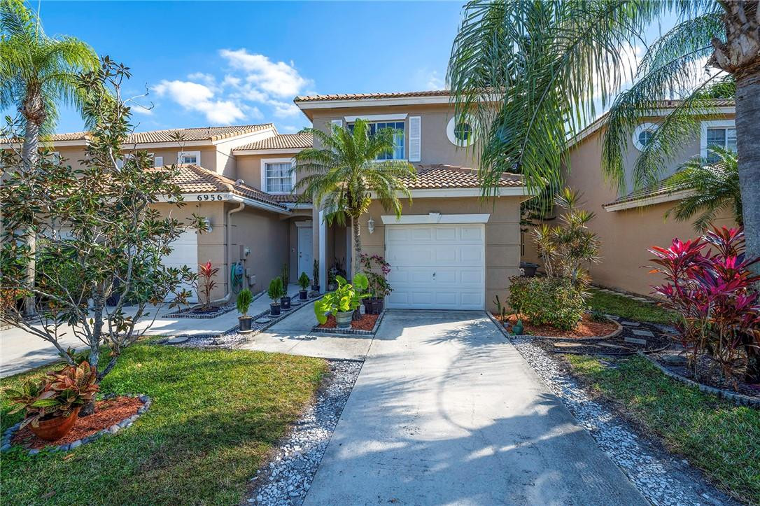 6960 Brook Hollow Road Lake Worth, FL 33467 - Photo 21 of 24 a front view of a house with garden