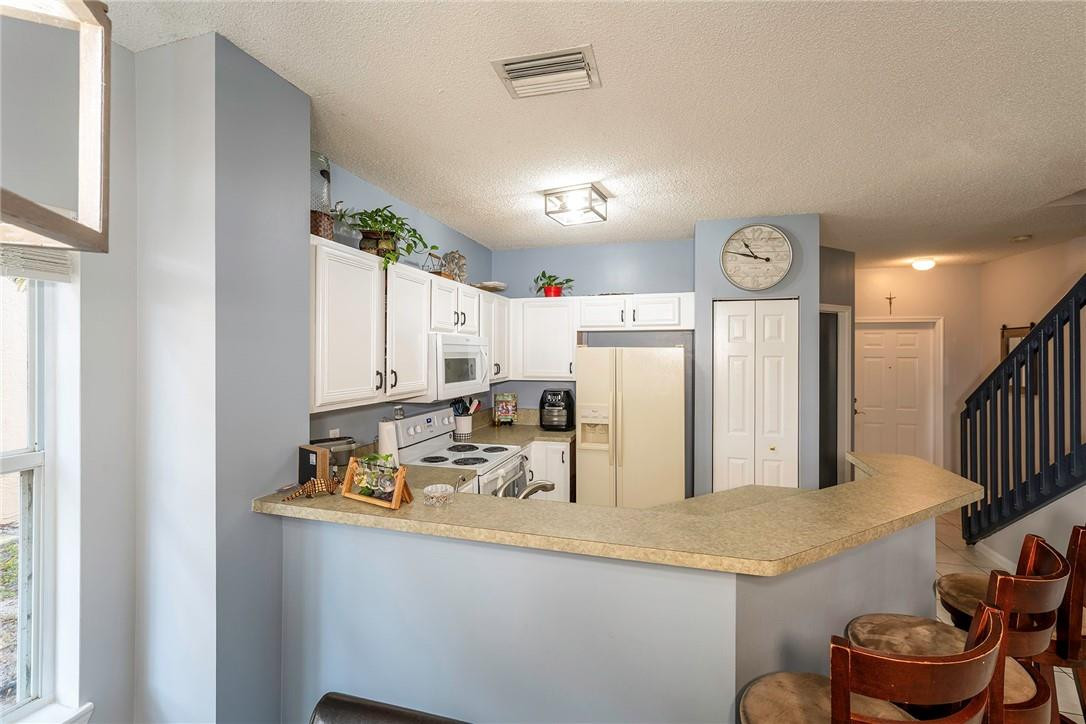 6960 Brook Hollow Road Lake Worth, FL 33467 - Photo 7 of 24 a kitchen with stainless steel appliances granite countertop a sink and a refrigerator