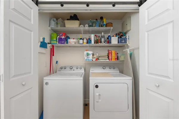 a view of a dining room and livingroom with furniture wooden floor a chandelier